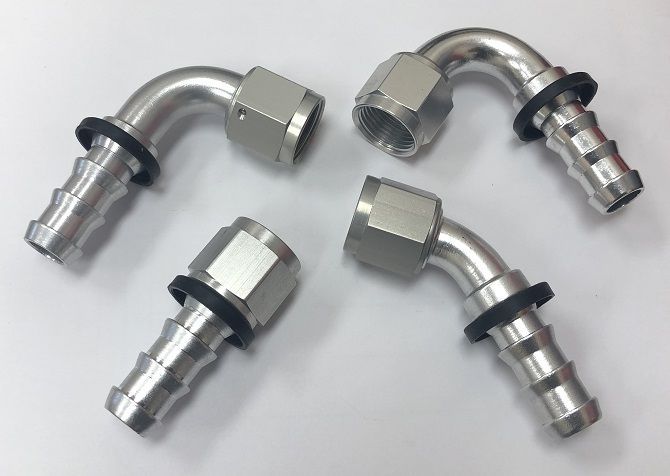 Four metal plumbing fittings on a white background