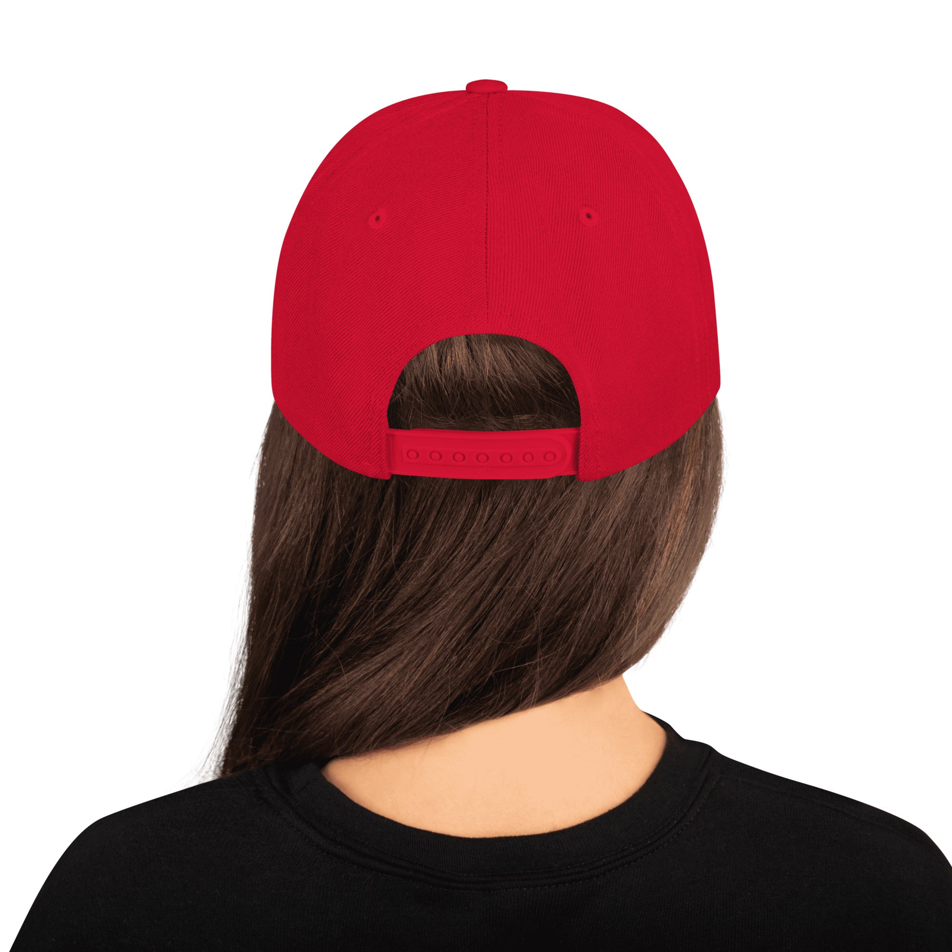 Product mockup image of the back of a classic snapback cap in a red color with red snap clasps, accents and bill. The model is wearing a black t-shirt and background behind her is white. The PSC logo with "PSC" in red, the flag and words "Performance Steering Components" are in back with a white background and black border are embroidered on the center of the cap.