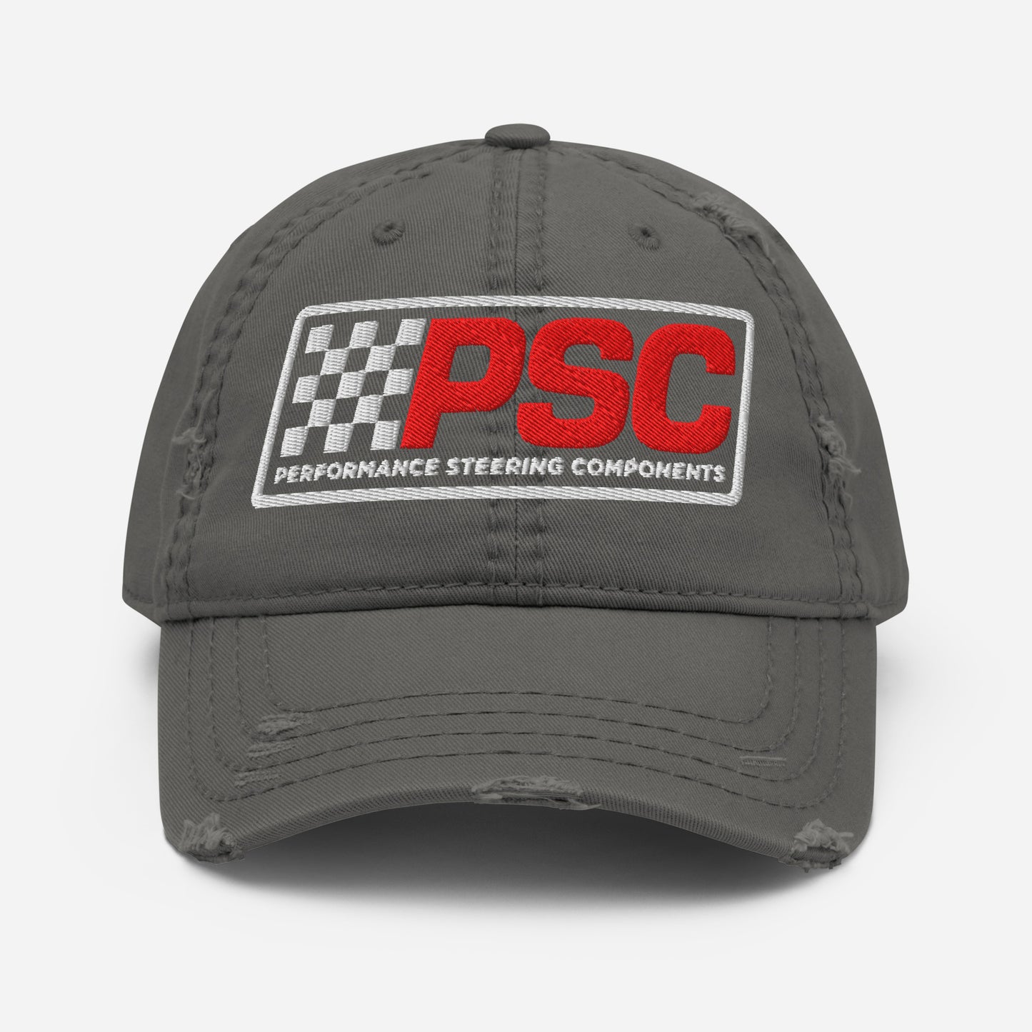 Distressed styled charcoal grey hat with a PSC logo where the letters are in a bold red and the flag emblem, border and words "Performance Steering Components" are in white. The background of the photo is white. 
