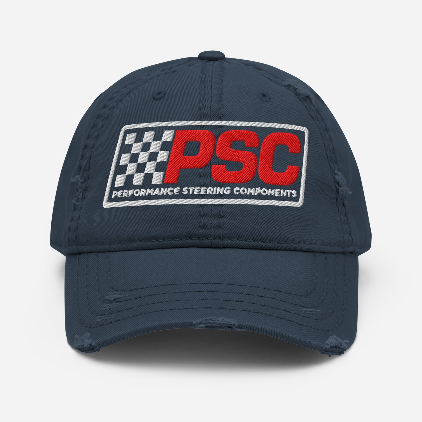 Distressed styled navy hat with a PSC logo where the letters are in a bold red and the flag emblem, border and words "Performance Steering Components" are in white. The background of the photo is white. 