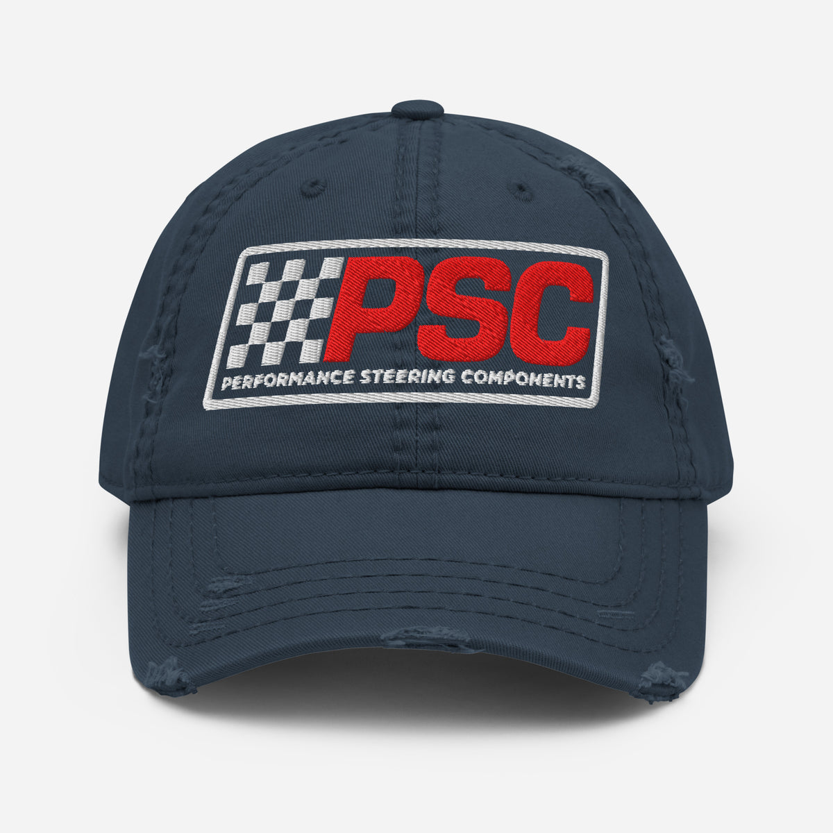 Distressed styled navy hat with a PSC logo where the letters are in a bold red and the flag emblem, border and words "Performance Steering Components" are in white. The background of the photo is white. 
