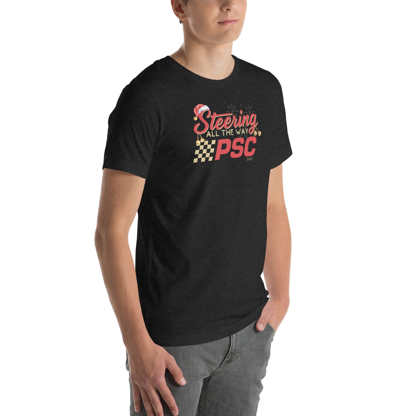 Angled front view of an adult model wearing a heather black short-sleeve T-shirt with a PSC logo and the phrase ‘Steering All the Way PSC 2025’ printed across the chest in red and gold lettering. There is a Santa hat on the "S" in steering, bells handing off the bottom of the "S" and "g" in steering and translucent snowflakes in the background as well as "2025" right bottom corner offset. He is facing the right frame of the image.