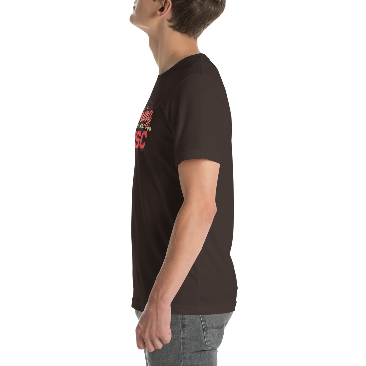 Side view of an adult model facing the left edge of the screen wearing a brown short-sleeve T-shirt you can see the edge of a red and gold design on the front of the shirt. The background is white.