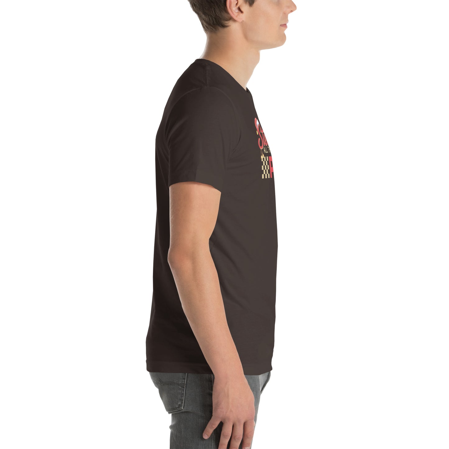 Side view of an adult model facing the right edge of the screen wearing a brown short-sleeve T-shirt you can see the edge of a red and gold design on the front of the shirt. The background is white.