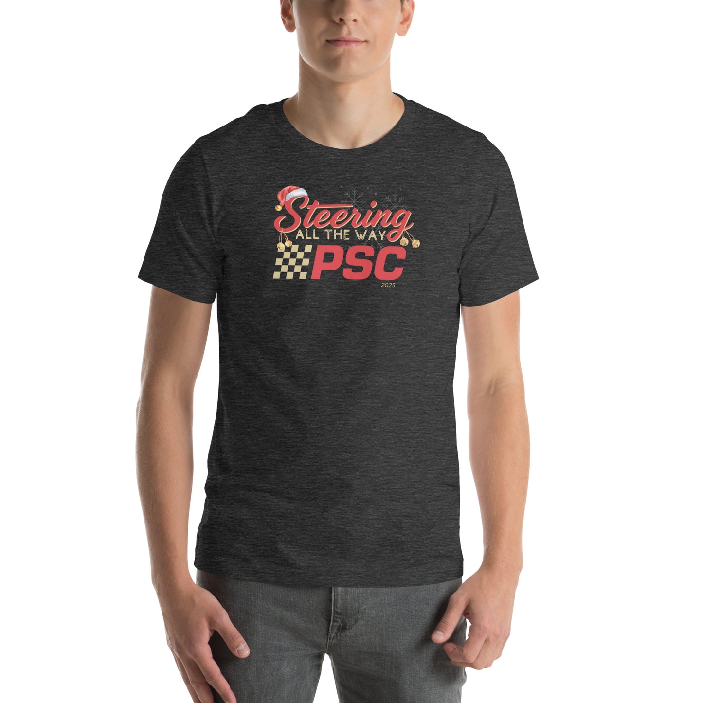 Front view of an adult model wearing a heather dark grey short-sleeve T-shirt with a PSC logo and the phrase ‘Steering All the Way PSC 2025’ printed across the chest in red and gold lettering. There is a Santa hat on the "S" in steering, bells handing off the bottom of the "S" and "g" in steering and translucent snowflakes in the background as well as "2025" right bottom corner offset.