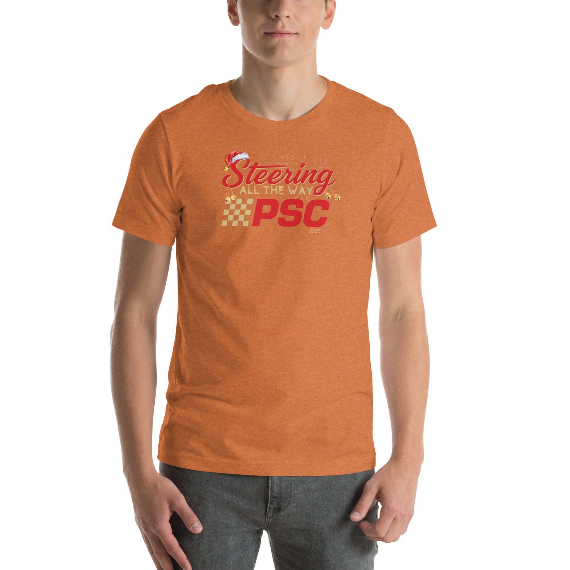 Front view of an adult model wearing a heather autumn orange short-sleeve T-shirt with a PSC logo and the phrase ‘Steering All the Way PSC 2025’ printed across the chest in red and gold lettering. There is a Santa hat on the "S" in steering, bells handing off the bottom of the "S" and "g" in steering and translucent snowflakes in the background as well as "2025" right bottom corner offset. 