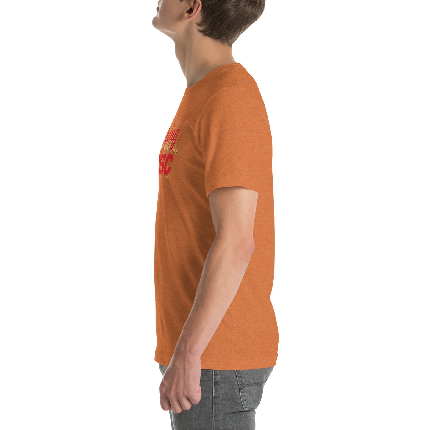 Side view of an adult model facing the left edge of the screen wearing a heather autumn orange short-sleeve T-shirt you can see the edge of a red and gold design on the front of the shirt. The background is white. 