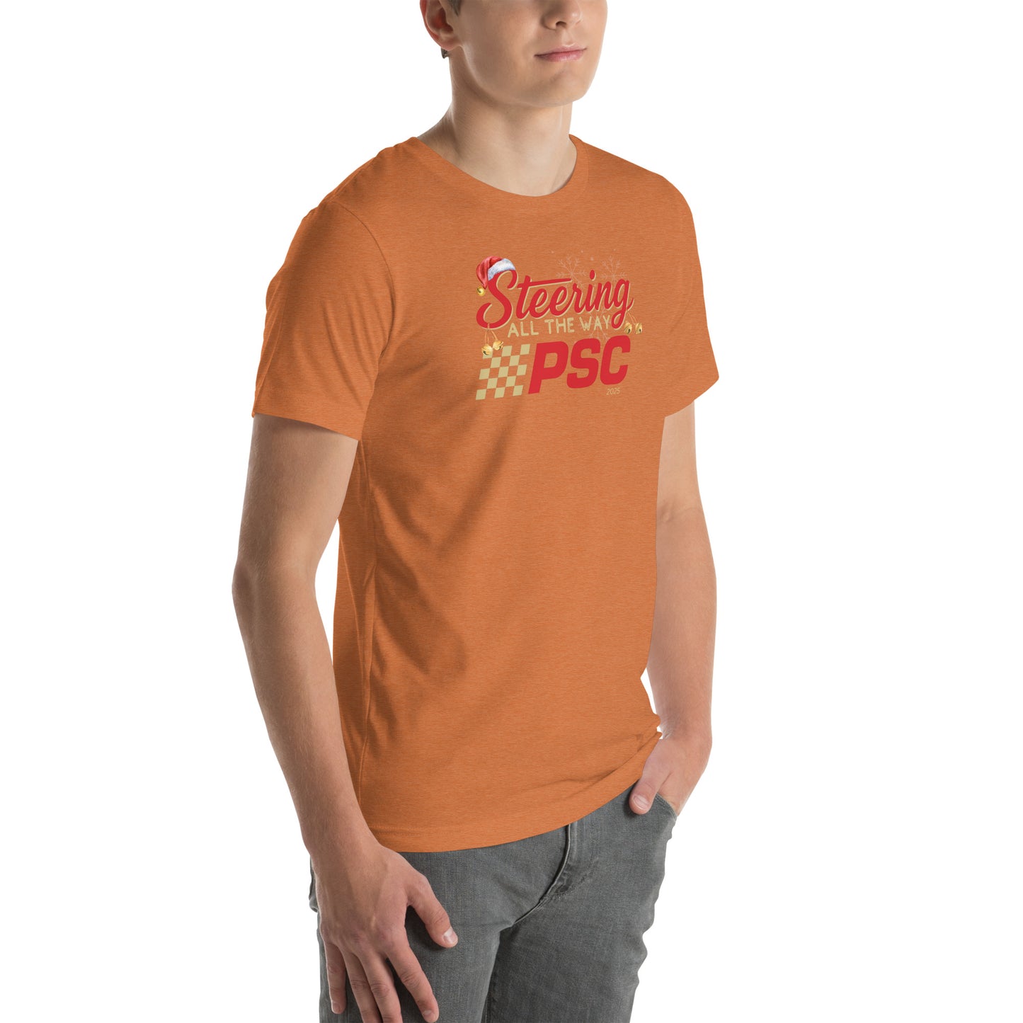 Angled front view of an adult model wearing a heather autumn orange short-sleeve T-shirt with a PSC logo and the phrase ‘Steering All the Way PSC 2025’ printed across the chest in red and gold lettering. There is a Santa hat on the "S" in steering, bells handing off the bottom of the "S" and "g" in steering and translucent snowflakes in the background as well as "2025" right bottom corner offset. He is facing the right frame of the image. 