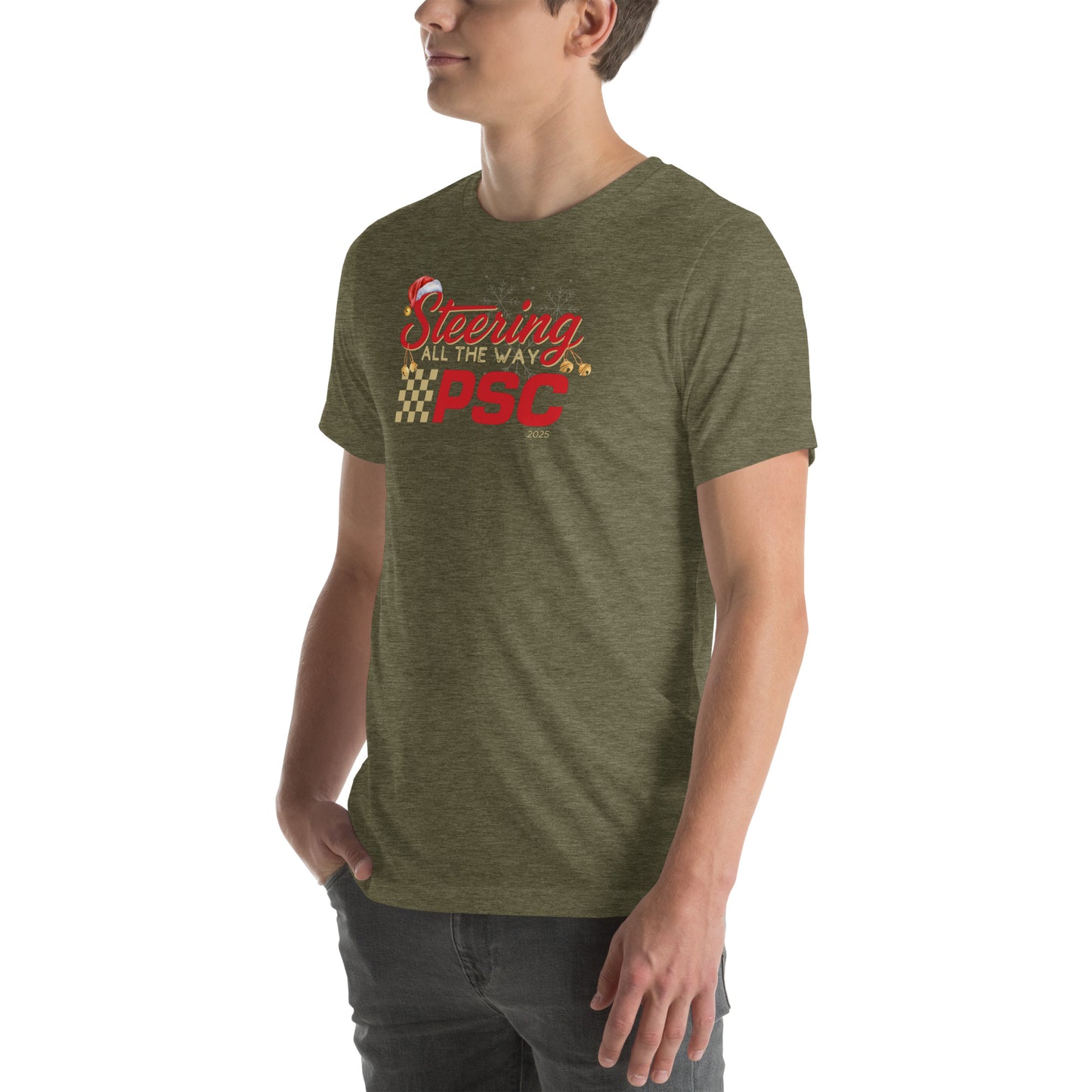 Angled front view of an adult model wearing a heather olive green short-sleeve T-shirt with a PSC logo and the phrase ‘Steering All the Way PSC 2025’ printed across the chest in red and gold lettering. There is a Santa hat on the "S" in steering, bells handing off the bottom of the "S" and "g" in steering and translucent snowflakes in the background as well as "2025" right bottom corner offset. He is facing the left frame of the image. 