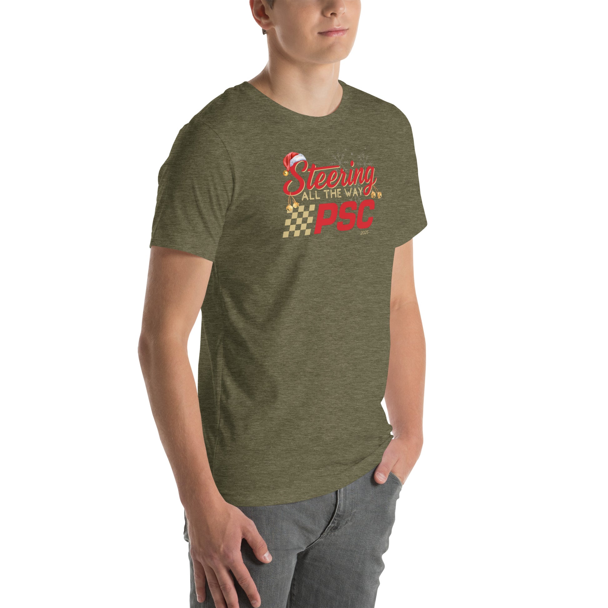 Angled front view of an adult model wearing a heather olive green short-sleeve T-shirt with a PSC logo and the phrase ‘Steering All the Way PSC 2025’ printed across the chest in red and gold lettering. There is a Santa hat on the "S" in steering, bells handing off the bottom of the "S" and "g" in steering and translucent snowflakes in the background as well as "2025" right bottom corner offset. He is facing the right frame of the image. 