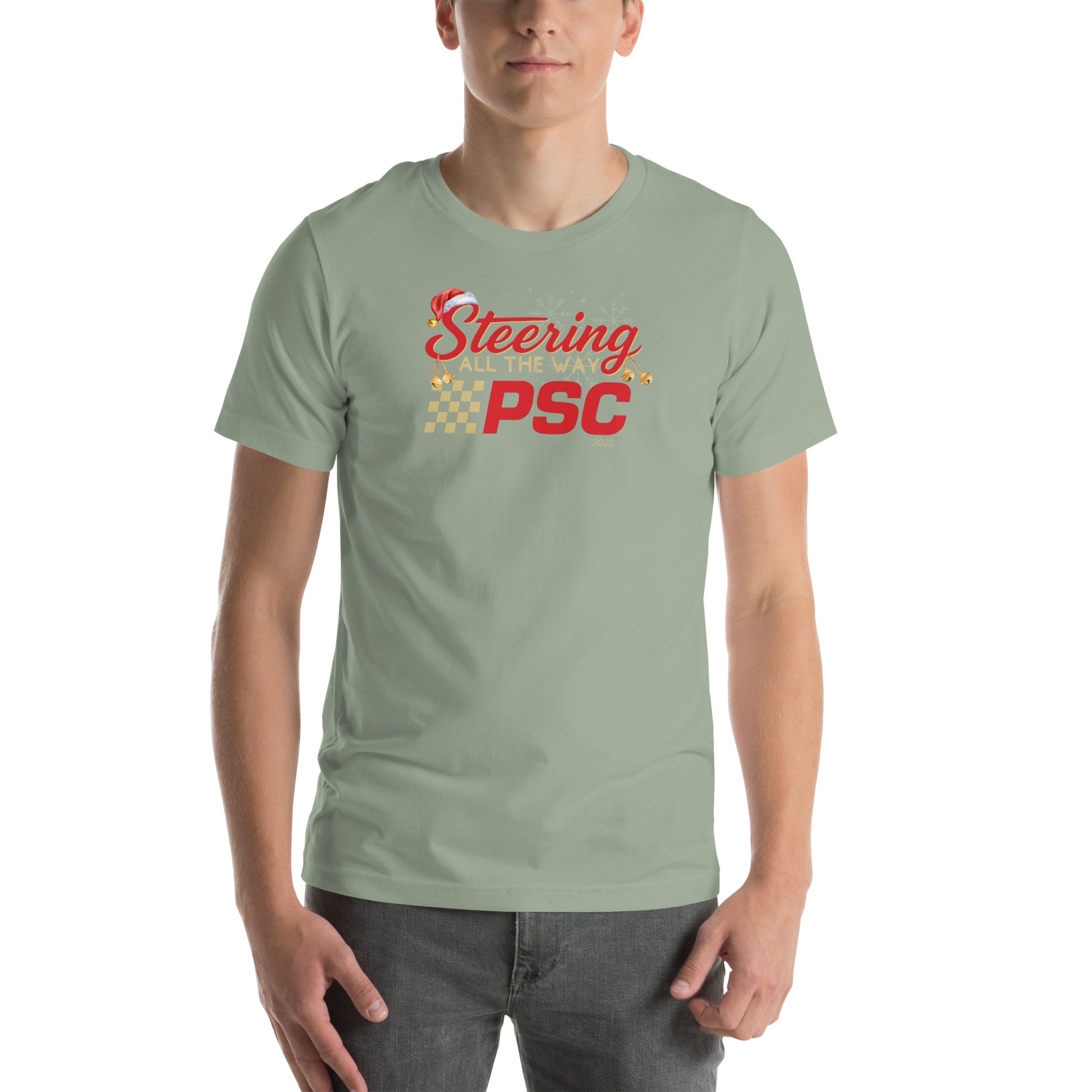 Front view of an adult model wearing a sage green short-sleeve T-shirt with a PSC logo and the phrase ‘Steering All the Way PSC 2025’ printed across the chest in red and gold lettering. There is a Santa hat on the "S" in steering, bells handing off the bottom of the "S" and "g" in steering and translucent snowflakes in the background as well as "2025" right bottom corner offset. 