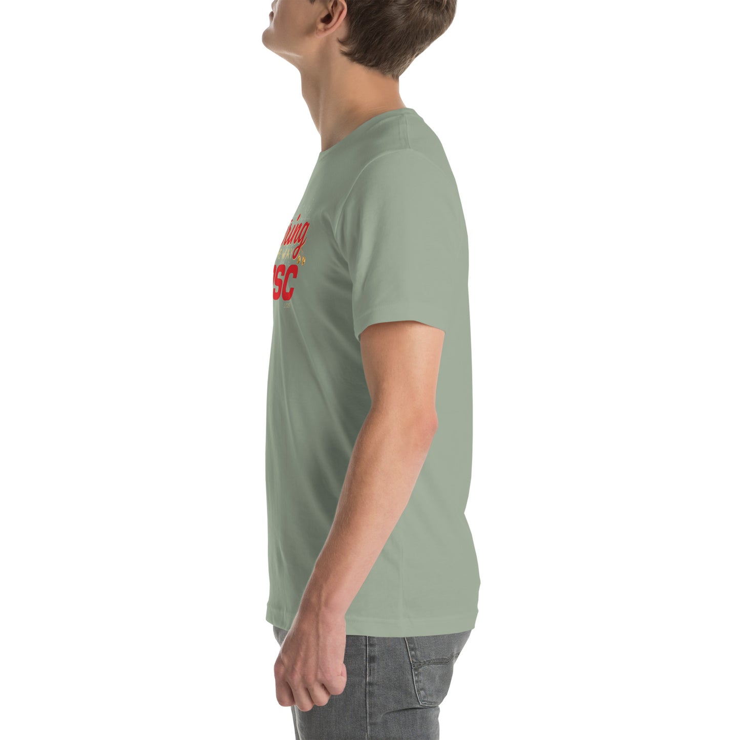 Side view of an adult model facing the left edge of the screen wearing a sage green short-sleeve T-shirt you can see the edge of a red and gold design on the front of the shirt. The background is white. 