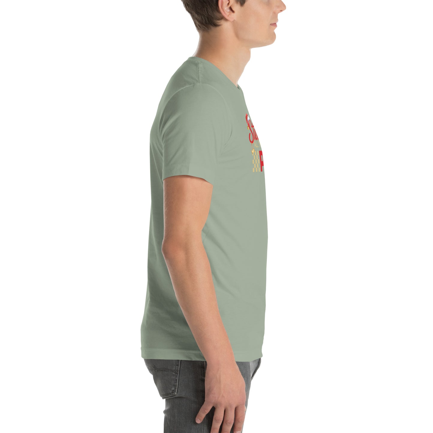 Side view of an adult model facing the right edge of the screen wearing a sage green short-sleeve T-shirt you can see the edge of a red and gold design on the front of the shirt. The background is white. 