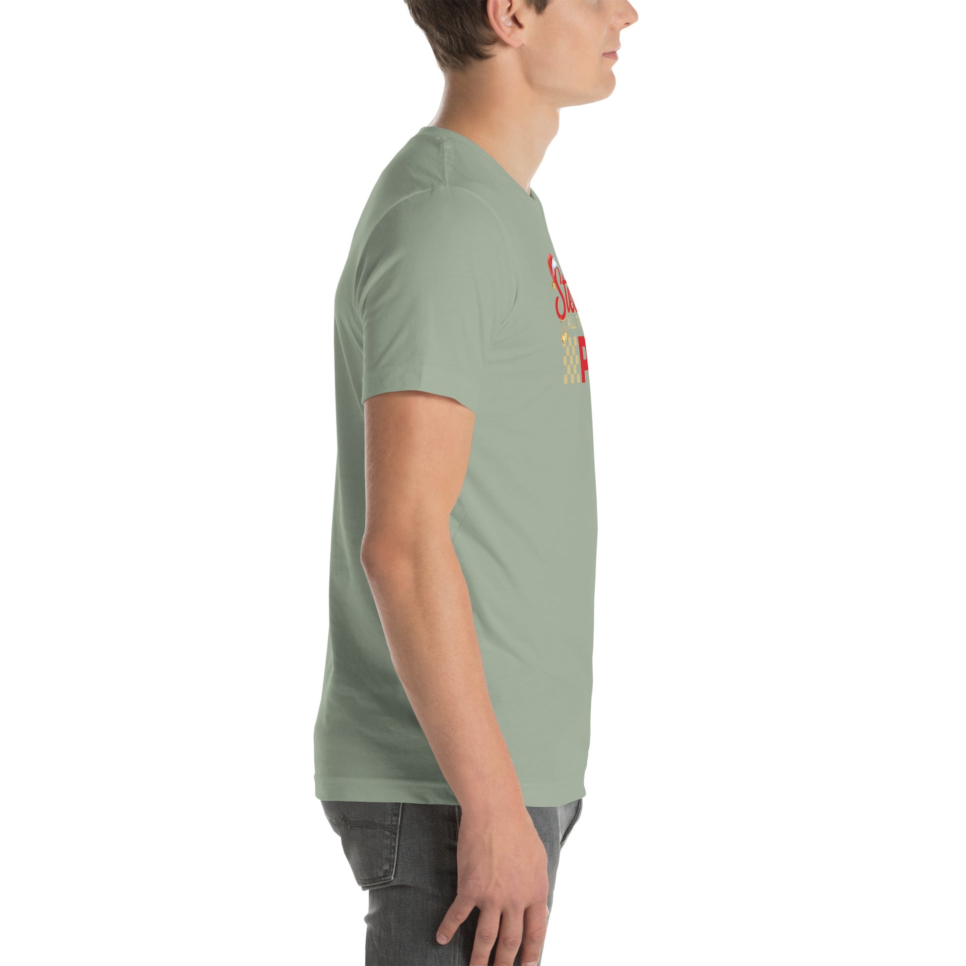 Side view of an adult model facing the right edge of the screen wearing a sage green short-sleeve T-shirt you can see the edge of a red and gold design on the front of the shirt. The background is white. 