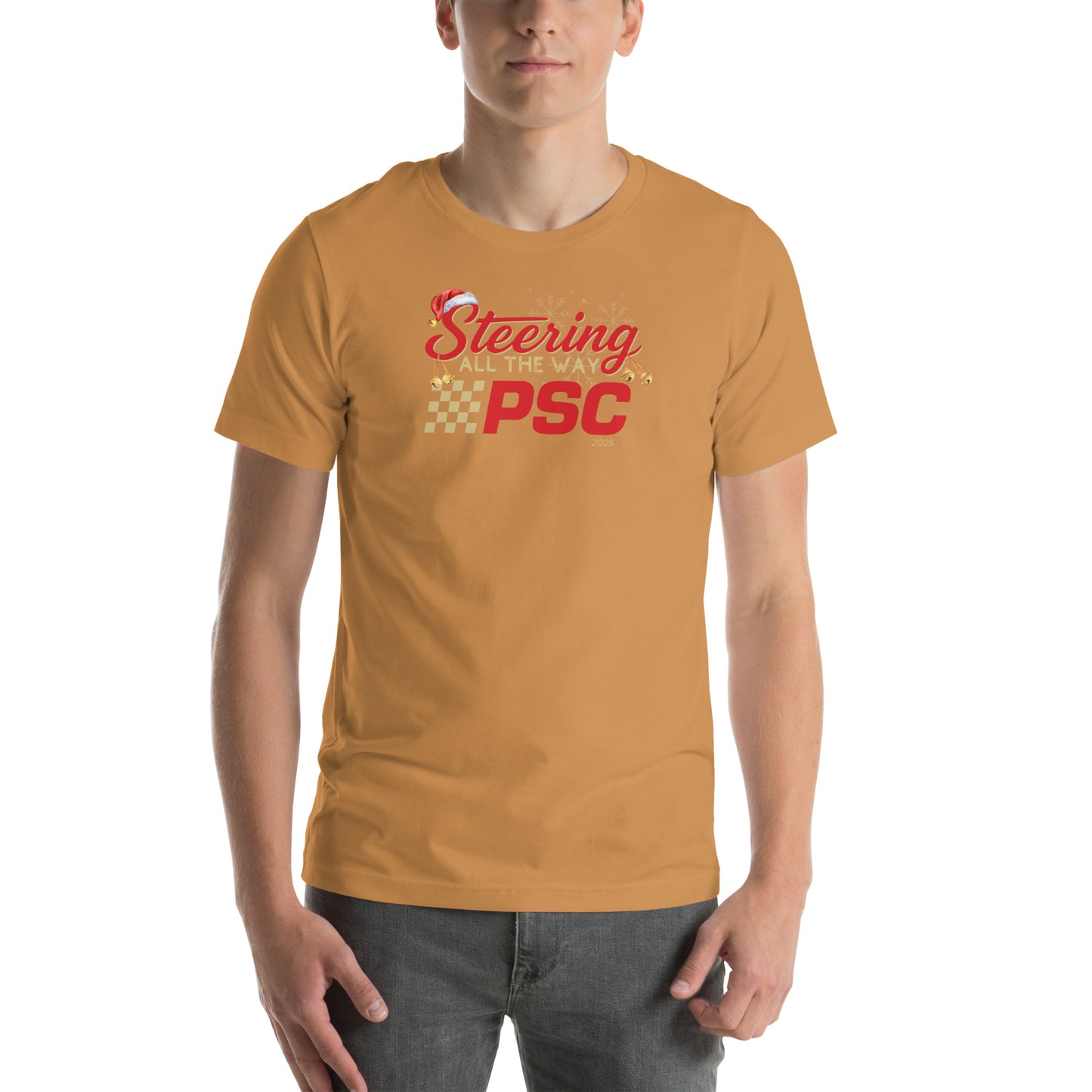 Front view of an adult model wearing a toast orange-brown short-sleeve T-shirt with a PSC logo and the phrase ‘Steering All the Way PSC 2025’ printed across the chest in red and gold lettering. There is a Santa hat on the "S" in steering, bells handing off the bottom of the "S" and "g" in steering and translucent snowflakes in the background as well as "2025" right bottom corner offset. 