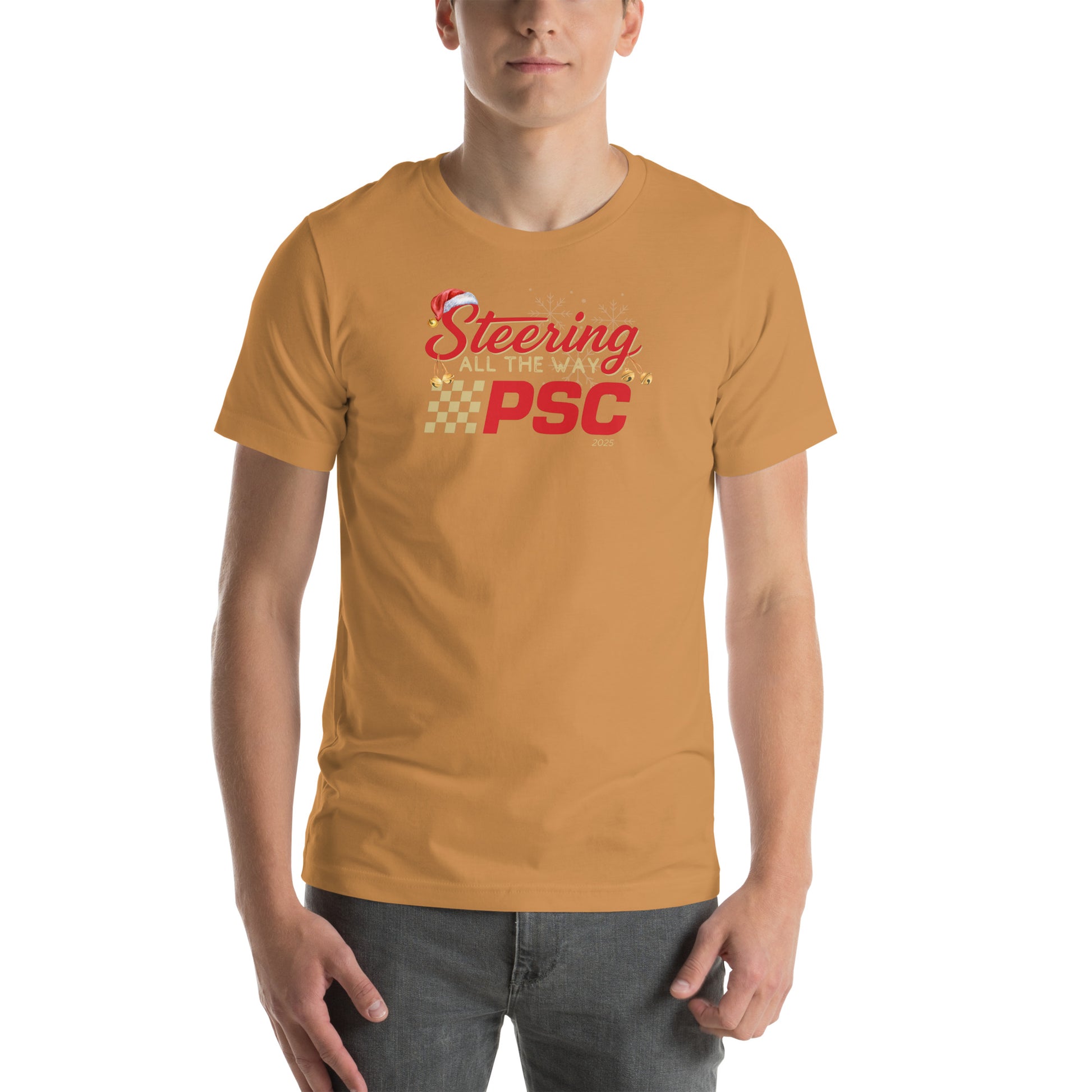 Front view of an adult model wearing a toast orange-brown short-sleeve T-shirt with a PSC logo and the phrase ‘Steering All the Way PSC 2025’ printed across the chest in red and gold lettering. There is a Santa hat on the "S" in steering, bells handing off the bottom of the "S" and "g" in steering and translucent snowflakes in the background as well as "2025" right bottom corner offset. 